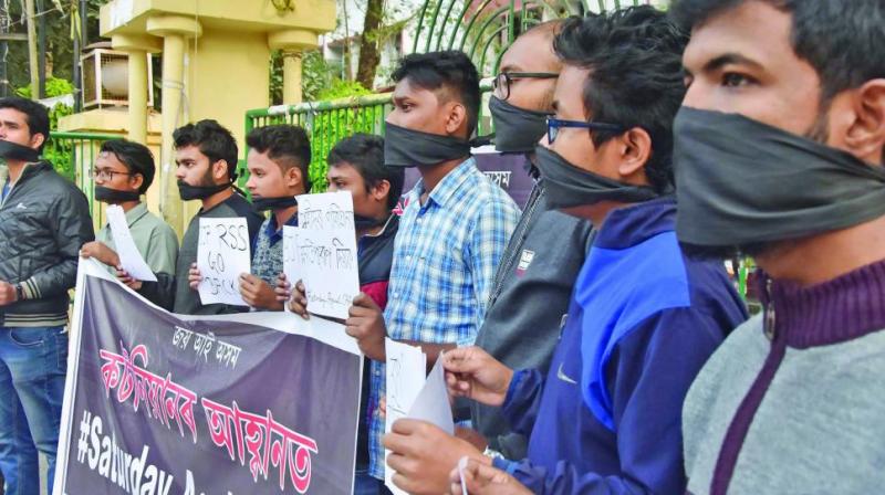 Students of Cotton University tie their mouth with black cloth as they stage a protest against the CAA in Guwahati. (Photo: PTI)