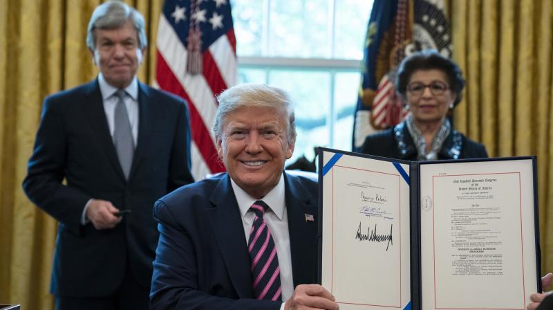President Donald Trump holds up the coronavirus aid package that will direct funds to small businesses, hospitals, and testing, in the Oval Office of the White House. AP Photo President Donald Trump holds up the coronavirus aid package that will direct funds to small businesses, hospitals, and testing, in the Oval Office of the White House. AP Photo