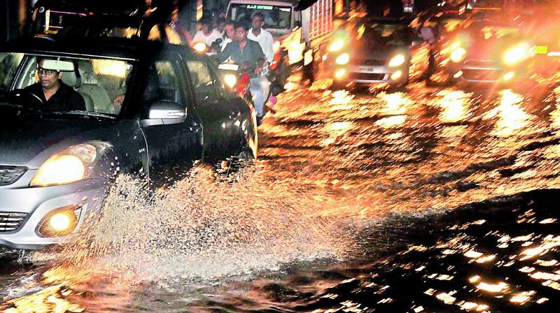 Vehicles wade through the flooded road near Boat Club after a sudden and heavy downpour battered the city on Friday night. (Photo: P. SURENDRA) Vehicles wade through the flooded road near Boat Club after a sudden and heavy downpour battered the city on Friday night. (Photo: P. SURENDRA)