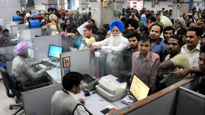 People stand in queues in a bank to deposit Rs 1000 and Rs 500 currency notes in Amritsar. (Photo: PTI) People stand in queues in a bank to deposit Rs 1000 and Rs 500 currency notes in Amritsar. (Photo: PTI)