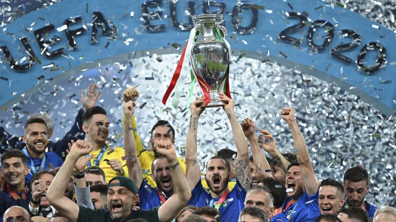 Italys Leonardo Bonucci (centre), holds the trophy as he celebrates with teammates after winning the Euro 2020 final against England in London on Sunday. (Photo: AP)