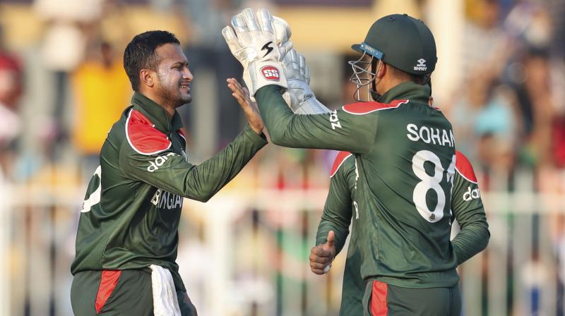 Bangladeshs Shakib Al Hasan (left) is congratulated by teammate Nurul Hasan after taking the wicket of Sri Lankas Pathum Nissanka during the Cricket Twenty20 World Cup match between Sri Lanka and Bangladesh in Sharjah on Sunday. (AP Photo)