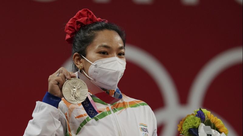 Tokyo: Indias Mirabai Chanu wearing Olympic Rings ear-ring poses for photographs while standing on the podium after receiving the silver medal in womens 49 kg category weightlifting event at the Summer Olympics 2020, in Tokyo, Saturday, July 24, 2021. (Photo: PTI)