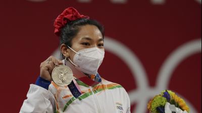  Tokyo: India's Mirabai Chanu wearing Olympic Rings ear-ring poses for photographs while standing on the podium after receiving the silver medal in women's 49 kg category weightlifting event at the Summer Olympics 2020, in Tokyo, Saturday, July 24, 2021. (Photo: PTI) 