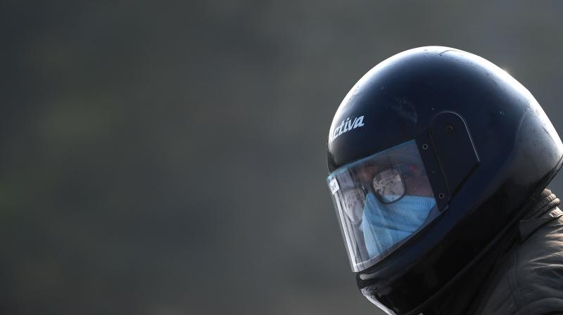 A motorist wearing a helmet and a facemask as a preventive measure against the Covid-19. (Photo:AFP)