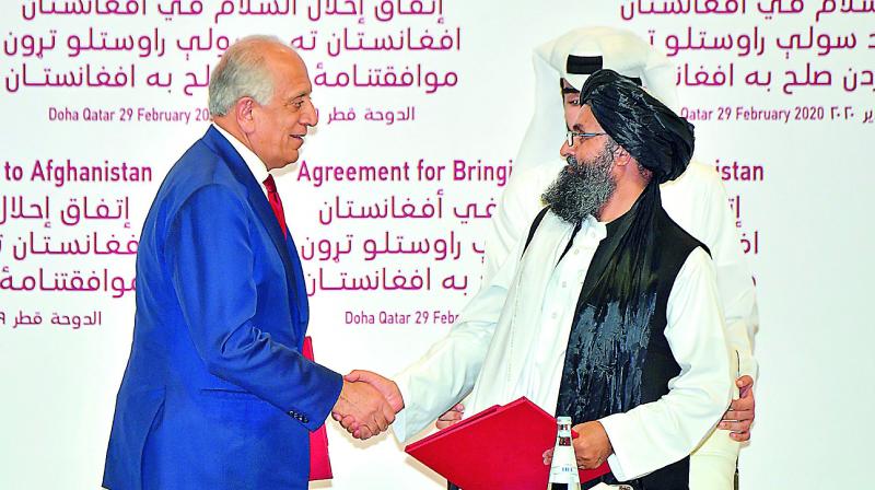 US Special Representative for Afghanistan Reconciliation Zalmay Khalilzad and Taliban co-founder Mullah Abdul Ghani Baradar shake hands after signing a peace agreement during a ceremony in the Qatari capital Doha on Saturday. US Special Representative for Afghanistan Reconciliation Zalmay Khalilzad and Taliban co-founder Mullah Abdul Ghani Baradar shake hands after signing a peace agreement during a ceremony in the Qatari capital Doha on Saturday.