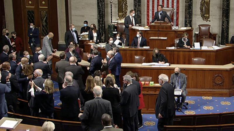 Democrats celebrate on the House floor late Friday, Nov. 5, 2021, in Washington, after the House approved a $1 trillion package of road and other infrastructure projects after Democrats resolved a months-long standoff between progressives and moderates, notching a victory that President Joe Biden and his party had become increasingly anxious to claim. (House Television via AP)