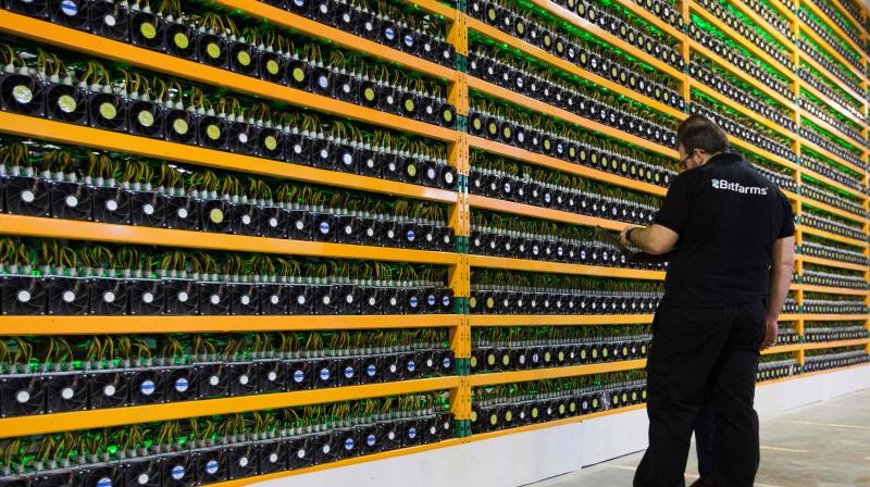 In this file photo taken on March 19, 2018 a technician inspects bitcoin mining at Bitfarms in Saint Hyacinthe, Quebec. (Photo | AFP)