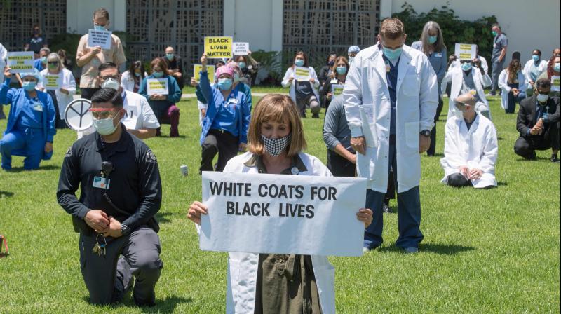 Ongoing protests following the death of George Floyd have focused attention on racial injustice in the US and how police use technology to track people. In this picture, doctors, nurses and other health care workers participate in a \White Coats for Black Lives\ event in solidarity with George Floyd and other black Americans killed by police officers, at the Queen of the Valley Hospital in West Covina, California on June 11, 2020. - George Floyds killing by a police officer touched off worldwide protests over racial and social injustice. (Photo | AFP) Ongoing protests following the death of George Floyd have focused attention on racial injustice in the US and how police use technology to track people. In this picture, doctors, nurses and other health care workers participate in a \White Coats for Black Lives\ event in solidarity with George Floyd and other black Americans killed by police officers, at the Queen of the Valley Hospital in West Covina, California on June 11, 2020. - George Floyds killing by a police officer touched off worldwide protests over racial and social injustice. (Photo | AFP)