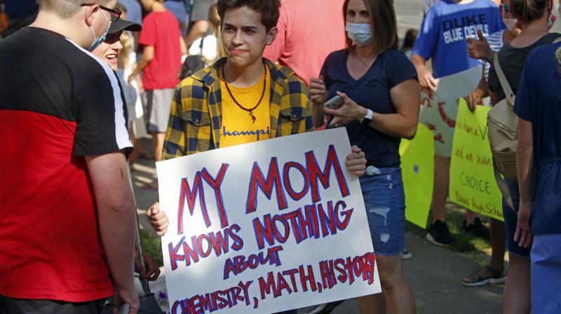 A group of children and parents protested the hybrid reopening of schools because they would prefer children to attend school five days a week, as before the pandemic. How likely children are to contract or spread the coronavirus has become a deeply contentious issue in the US, with reopening schools essential to enabling many parents to go back to work. Children are known to be far less likely to fall seriously ill or die from the virus: less than one percent of children who test positive for COVID-19 end up dying, according to a Europe-wide study released in June. (Photo | AP) A group of children and parents protested the hybrid reopening of schools because they would prefer children to attend school five days a week, as before the pandemic. How likely children are to contract or spread the coronavirus has become a deeply contentious issue in the US, with reopening schools essential to enabling many parents to go back to work. Children are known to be far less likely to fall seriously ill or die from the virus: less than one percent of children who test positive for COVID-19 end up dying, according to a Europe-wide study released in June. (Photo | AP)