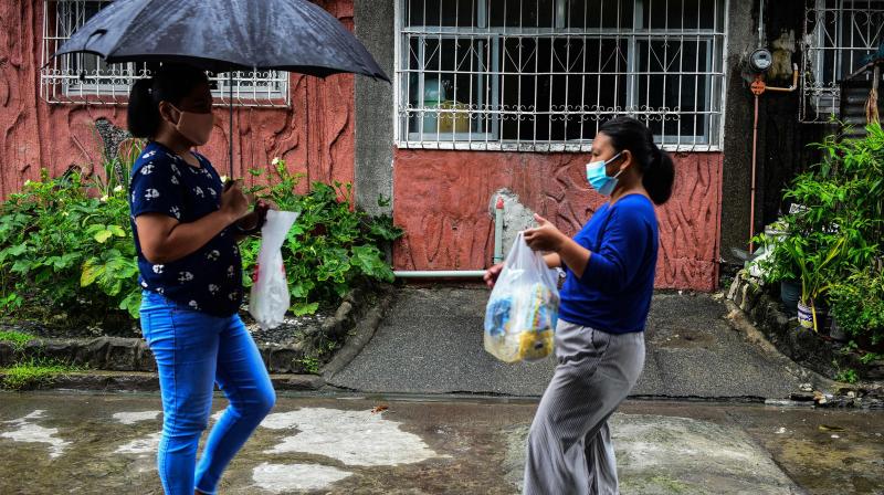 At least 98 online bartering groups, some with tens of thousands of members, are operating across the archipelago, according to an AFP tally. This photo taken on July 29, 2020 shows Lorraine Ann Imperio (L) carrying a bag of old milk bottles as she meets with Reniel Bariso to barter their goods in Las Pinas City, suburban Manila. (Photo | AFP - Maria Tan) At least 98 online bartering groups, some with tens of thousands of members, are operating across the archipelago, according to an AFP tally. This photo taken on July 29, 2020 shows Lorraine Ann Imperio (L) carrying a bag of old milk bottles as she meets with Reniel Bariso to barter their goods in Las Pinas City, suburban Manila. (Photo | AFP - Maria Tan)