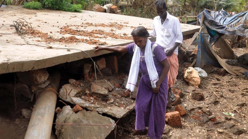 Karthikeyan and wife in front of their house which sank at Cheriya Tekkanam in Kunnukara panchayath near Paravur. (Photo:SUNOJ NINAN MATHEW) Karthikeyan and wife in front of their house which sank at Cheriya Tekkanam in Kunnukara panchayath near Paravur. (Photo:SUNOJ NINAN MATHEW)