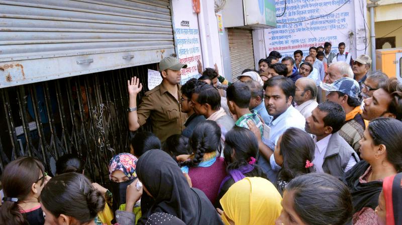 People in long queue to deposit scrapped notes. People in long queue to deposit scrapped notes.