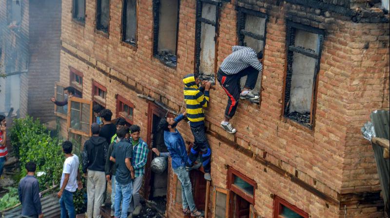 People inspect the damaged house where four militants and one policeman were killed during an encounter, at Srigafwara in Anantnag district of south Kashmir on Friday, June 22, 2018. Police killed four militants, including chief of the banned Islamic State Jammu and Kashmir (ISJK) Dawood Ahmed Sofi, in a remote mountain village in south Kashmir's Anantnag district. —PTI People inspect the damaged house where four militants and one policeman were killed during an encounter, at Srigafwara in Anantnag district of south Kashmir on Friday, June 22, 2018. Police killed four militants, including chief of the banned Islamic State Jammu and Kashmir (ISJK) Dawood Ahmed Sofi, in a remote mountain village in south Kashmir's Anantnag district. —PTI