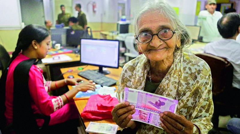 An 85-year-old woman with the new Rs 2,000 currency notes she received at a bank on Sunday. (Photo: PTI) An 85-year-old woman with the new Rs 2,000 currency notes she received at a bank on Sunday. (Photo: PTI)