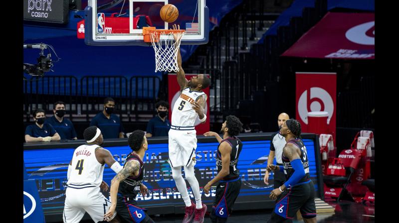 Will Barton (centre) of Denver Nuggets goes up for the shot over Philadelphia 76ers Isaiah Joe (cenre right) during their NBA game in Philadelphia on Saturday. · AP