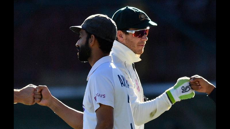 Indias captain Ajinkya Rahane (left) and Australias captain Tim Paine greet at the end of the third cricket Test match between Australia and India at the Sydney Cricket Ground on Monday. -- AFP