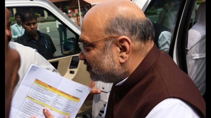 Home Minister Amit Shah was captured on camera by a photographer with documents between his folded hands as he walked into Parliament on Monday. (Photo: AFP) Home Minister Amit Shah was captured on camera by a photographer with documents between his folded hands as he walked into Parliament on Monday. (Photo: AFP)