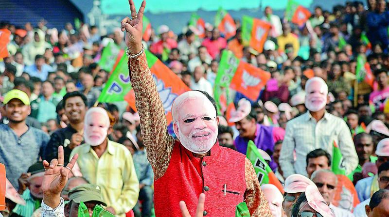 BJP supporters wearing Prime Minister Narendra Modi’s mask wave during the Jabab Maguchhi Odisha rally at Chow-field, Baripada, in Mayurbhanj district of Odisha on Saturday. (PTI) BJP supporters wearing Prime Minister Narendra Modi’s mask wave during the Jabab Maguchhi Odisha rally at Chow-field, Baripada, in Mayurbhanj district of Odisha on Saturday. (PTI)