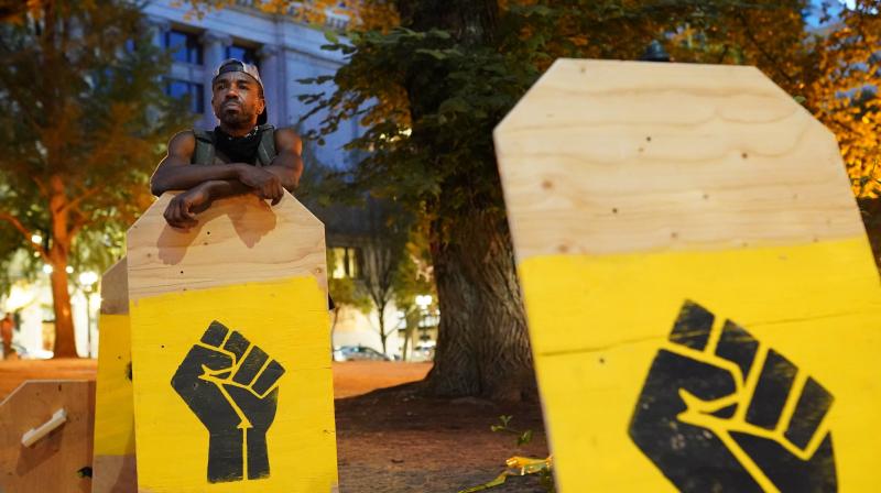 A protester rests on a protest shield. (AFP)