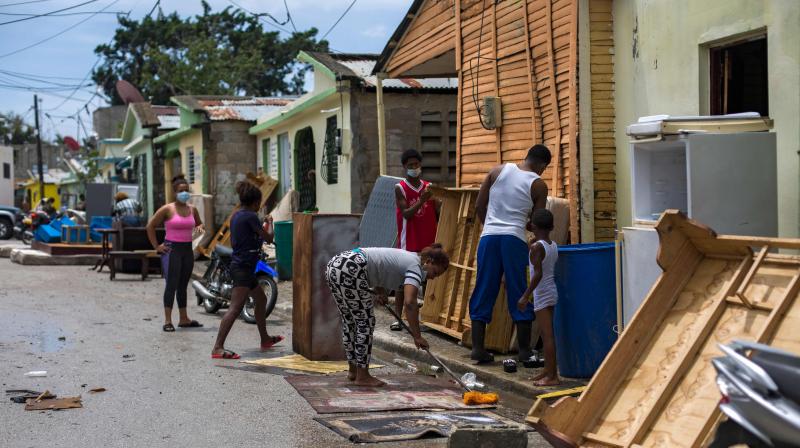 People clean and dry their belongings after the passage of tropical storm Isaias, with which heavy rains caused the overflowing of the Magua River in Hato Mayor, Dominican Republic. (AFP)