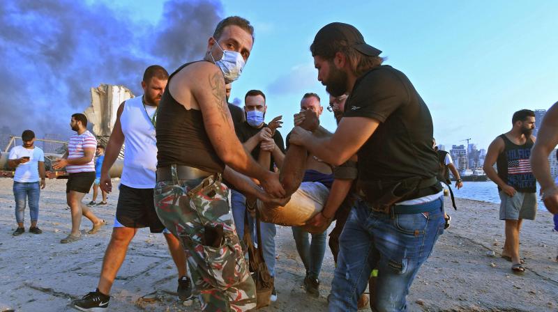 A wounded man is evacuated from a boat following of an explosion at the port of the Lebanese capital Beirut, on August 4, 2020. (AP)