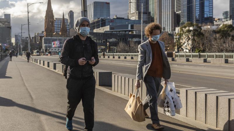 Pedestrians walk away from the central business district as lockdown due to the continuing spread of the coronavirus starts in Melbourne. (AP)