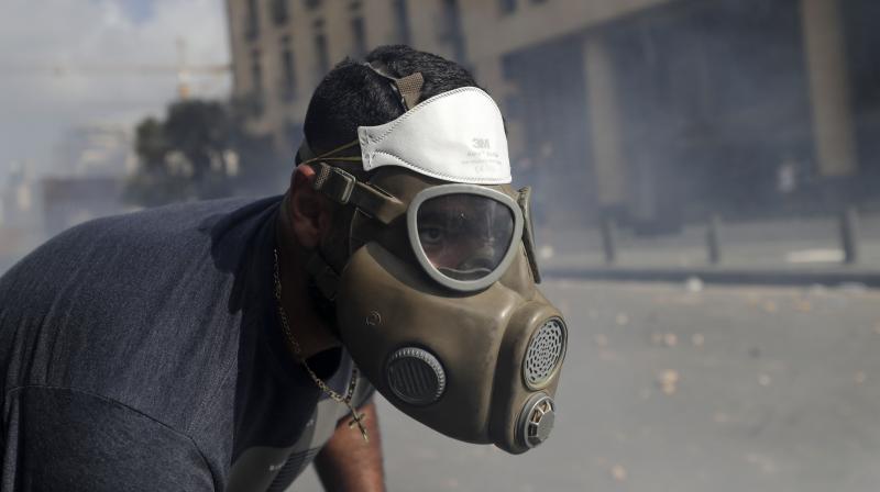 An anti-government protester clashes with riot police officers during a protest against the political elites and the government after this weeks deadly explosion at Beirut port which devastated large parts of the capital in Beirut, Lebanon. (AP)