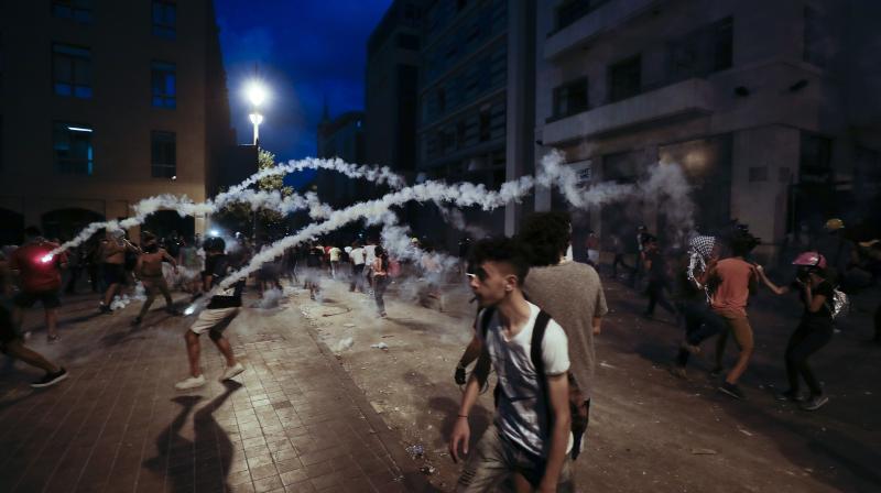 Teargas canisters fly during anti-government protest in Beirut. (AP)