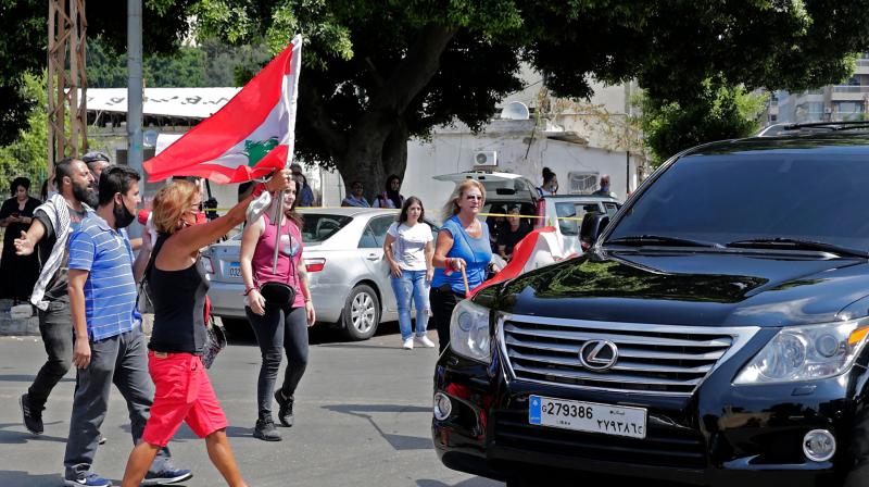 Lebanese anti-government protesters attack a vehicle belonging to a member of the parliament upon his arrival to the parliamentary session at the UNESCO Palace in Beirut. (AFP)