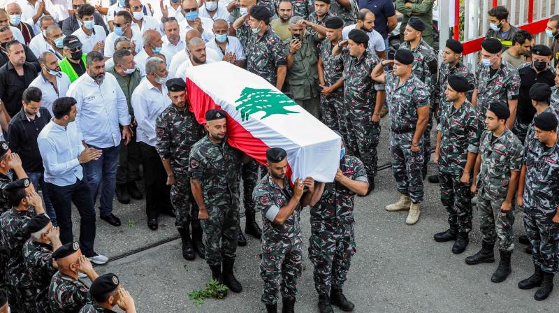 Firefighters carry the coffin of their comrade Ralph Malachi, who was killed in the monster explosion at the port of Beirut and whose remains were recently found and identified, draped in the Lebanese national flag, during a funerary ceremony at the civil defence headquarters in the Karantina (La Quarantaine or Quarantina) neighbourhood of the capital just by the ravaged port. (AFP)