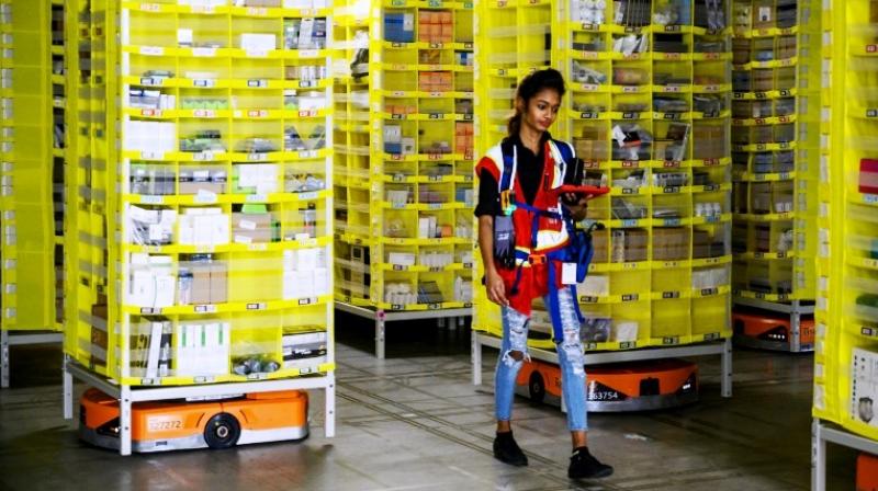 Amazon employee Deasahni Bernard moves among robots at the 855,000-square-foot Amazon fulfilment centre in Staten Island. (Photo: AFP) Amazon employee Deasahni Bernard moves among robots at the 855,000-square-foot Amazon fulfilment centre in Staten Island. (Photo: AFP)