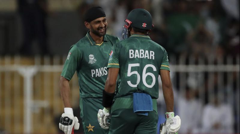 Pakistans Shoaib Malik (left) celebrates with captain Babar Azam after hitting a boundary during the T20 World Cup match against Scotland in Sharjah on Sunday. (AP Photo)