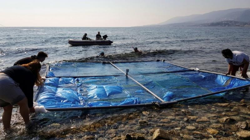 The slow speed of the solar-powered barrier prevents it from holding onto the plastic after it scoops it up. (Photo: AFP) The slow speed of the solar-powered barrier prevents it from holding onto the plastic after it scoops it up. (Photo: AFP)