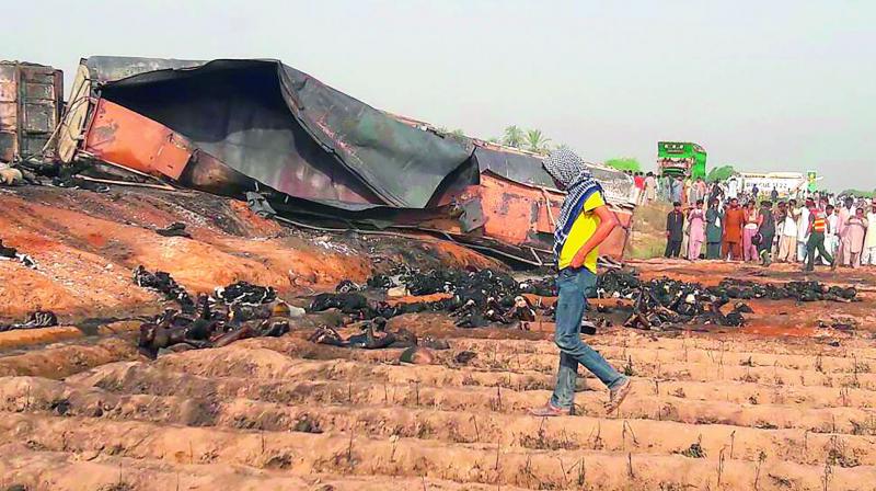 Charred bodies lie beside the burnt trailer of the oil tanker that caught fire following an accident on a highway near the town of Ahmedpur East, some 670 km from Islamabad on Sunday. (Photo: AFP) Charred bodies lie beside the burnt trailer of the oil tanker that caught fire following an accident on a highway near the town of Ahmedpur East, some 670 km from Islamabad on Sunday. (Photo: AFP)