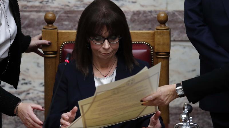 Newly elected Greek President Katerina Sakellaropoulou signs protocol documents during the swearing in ceremony at the Greek Parliament in Athens.