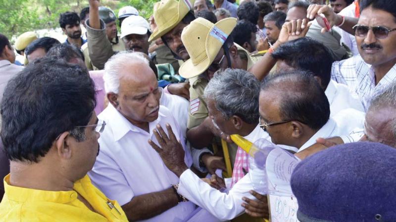 Chief Minister B.S. Yediyurappa listens to grievances of people affected by rain in Haveri on Saturday. (Photo: KPN) Chief Minister B.S. Yediyurappa listens to grievances of people affected by rain in Haveri on Saturday. (Photo: KPN)