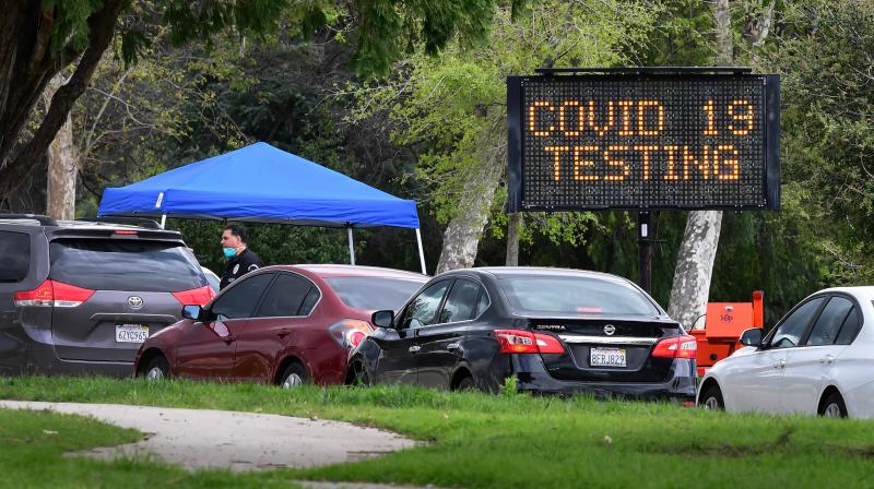 A police officer mans the entrance to a coronavirus (COVID-19) testing center in Hansen Dam Park on March 25, 2020 in Pacoima, California. (Photo | AFP)