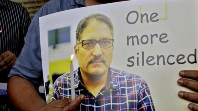 A journalist participates in a silent protest against the brutal killing of a senior Kashmiri journalist Shujaat Bukhari, portrait seen, in Kolkata on June 15, 2018. (Photo: AP) A journalist participates in a silent protest against the brutal killing of a senior Kashmiri journalist Shujaat Bukhari, portrait seen, in Kolkata on June 15, 2018. (Photo: AP)