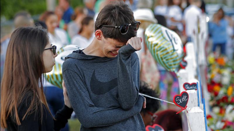 Daniel Bishop, 16, a student at Marjory Stoneman Douglas High School, cries at a makeshift memorial outside the school, in Parkland, Fla., Sunday, Feb. 18, 2018. Nikolas Cruz, a 19-year-old who had been expelled from the school, is being held without bail in the Broward County Jail, accused of 17 counts of first-degree murder. (Photo: AP) Daniel Bishop, 16, a student at Marjory Stoneman Douglas High School, cries at a makeshift memorial outside the school, in Parkland, Fla., Sunday, Feb. 18, 2018. Nikolas Cruz, a 19-year-old who had been expelled from the school, is being held without bail in the Broward County Jail, accused of 17 counts of first-degree murder. (Photo: AP)