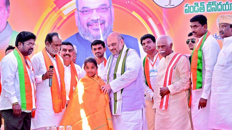 BJP national president Amit Shah felicitates Banda Geethika, a Class VII girl and an expert in yoga on Wednesday. Geethika had earlier done yoga along with Prime Minister Narendra Modi. She is native of Gundrampally village of Chityala mandal in Nalgonda district. She has participated in national-level yoga events and would visit New Delhi next month to do yoga with the PM again. (Photo: DC) BJP national president Amit Shah felicitates Banda Geethika, a Class VII girl and an expert in yoga on Wednesday. Geethika had earlier done yoga along with Prime Minister Narendra Modi. She is native of Gundrampally village of Chityala mandal in Nalgonda district. She has participated in national-level yoga events and would visit New Delhi next month to do yoga with the PM again. (Photo: DC)