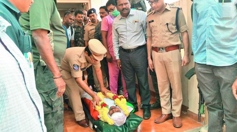 Bhadradri-Kothagudem district SP Amber Kishore Jha pays tribute to the slain cop Susheel Kumar in Bhadrachalam on Friday. Bhadradri-Kothagudem district SP Amber Kishore Jha pays tribute to the slain cop Susheel Kumar in Bhadrachalam on Friday.