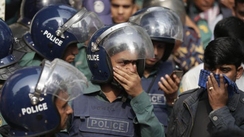 Bangladesh policemen cover their nose to protect themselves from the smell of teargas during a raid in a building in Dhaka, Bangladesh. (Photo: AP) Bangladesh policemen cover their nose to protect themselves from the smell of teargas during a raid in a building in Dhaka, Bangladesh. (Photo: AP)
