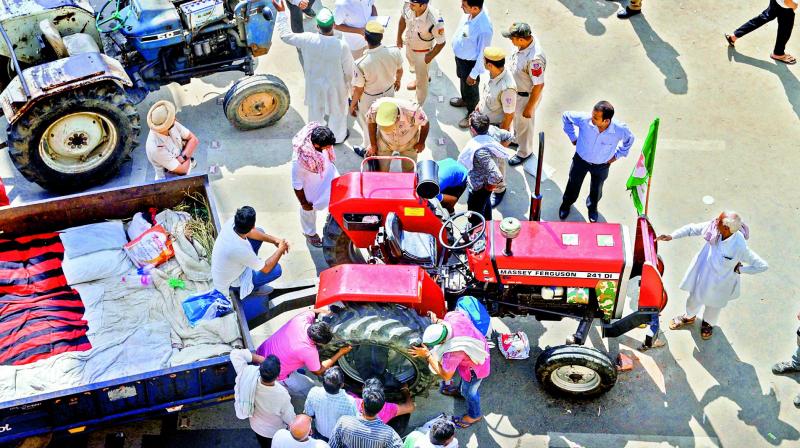 Farmers repair their tractors after ending Kisan Kranti Padyatra at NH24 on Delhi-UP border on Tuesday. (Photo:PTI) Farmers repair their tractors after ending Kisan Kranti Padyatra at NH24 on Delhi-UP border on Tuesday. (Photo:PTI)