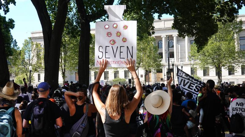 People attend a rally in support of Jacob Blake and his family in front of the Kenosha County Courthouse on August 29, 2020 in Kenosha, Wisconsin. Blake was shot seven times in the back in front of his three children by a police officer in Kenosha. (AFP)