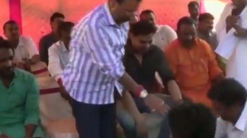 In the video, a BJP worker, Pawan, can be seen washing Dubey's feet and drinking the water used for it. (Photo: Screengrab | ANI) In the video, a BJP worker, Pawan, can be seen washing Dubey's feet and drinking the water used for it. (Photo: Screengrab | ANI)