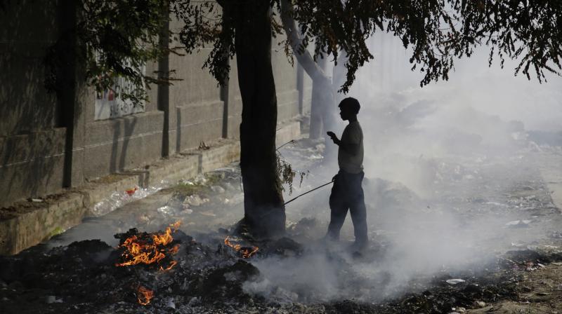 A boy stands next to burning garbage on the outskirts of New Delh on Tuesday. (Photo: AP) A boy stands next to burning garbage on the outskirts of New Delh on Tuesday. (Photo: AP)