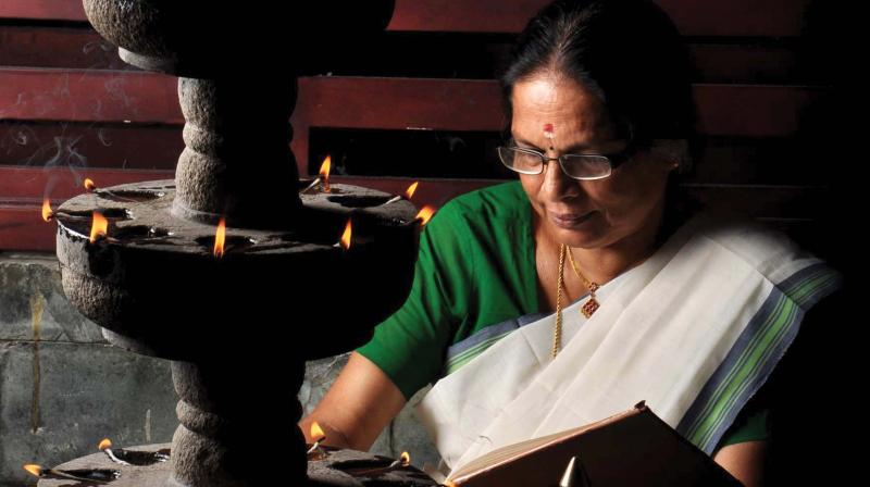 A woman reads the Ramayana at home during Karkidakam. (file pic) A woman reads the Ramayana at home during Karkidakam. (file pic)