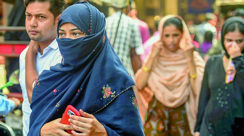 A Muslim woman walking in a market, near Jama Masjid in New Delhi on Wednesday. (Photo:PTI) A Muslim woman walking in a market, near Jama Masjid in New Delhi on Wednesday. (Photo:PTI)