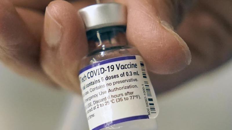 A doctor loads a dose of Pfizer COVID-19 vaccine into a syringe at a mobile vaccination clinic in Worcester, Massachusetts (AP Photo/Steven Senne, File)